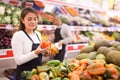 Saleswoman in supermarket of Latin American origin checking product