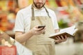 Supermarket Worker Using Smartphone Royalty Free Stock Photo