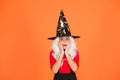 Supernatural charmer gray hair. kid enchantress orange background. happy halloween. magic fantasy. scared small girl