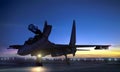 Supersonic fighter jet on air force base airfield getting ready to take off at sunset Royalty Free Stock Photo