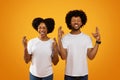 Superstitious african american couple cross fingers on yellow