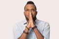 Hopeful black man in studio join hands in prayer