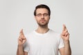 Superstitious worried millennial man in eyeglasses wishing good luck. Royalty Free Stock Photo