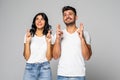 Superstitious young couple crossing fingers wish for good luck concept. Funny stressed man and woman begging for help hoping for