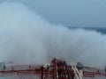 A supertanker VLCC combined sailing on the sea, splashing a blossoming spray