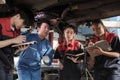 Supervisor engineer is teaching mechanic workers about car repair at a garage. Royalty Free Stock Photo