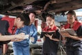 Supervisor engineer is teaching mechanic workers about car repair at a garage. Royalty Free Stock Photo