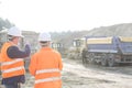 Supervisor explaining plan to colleague at construction site Royalty Free Stock Photo