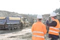 Supervisor explaining plan to colleague at construction site Royalty Free Stock Photo