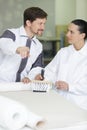 supervisor giving instructions to female colleague applying wallpaper paste