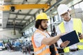 Supervisor with manual worker discussing over clipboard in metal industry Royalty Free Stock Photo