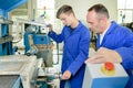 Supervisor overseeing apprentice using machinery