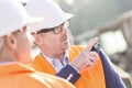 Supervisor showing something to colleague at construction site