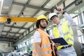 Supervisor showing something to manual worker in metal industry