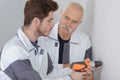 Supervisor watching apprentice use drill on interior wall Royalty Free Stock Photo