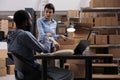 Supervisor woman putting client order in cardboard box preparing packages for delivery