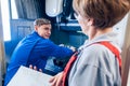 Supervisor watching young worker changing setup of lathe machine