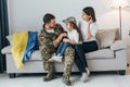 Supoort Ukraine conception. Soldier in uniform is at home with his wife and daughter Royalty Free Stock Photo