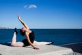 Supple young dancer does the splits on a big stone block.