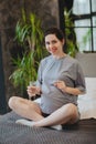 Pregnant woman taking prenatal vitamins during pregnancy, holding water glass and pill in hands Royalty Free Stock Photo