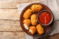 Suppli al Telefono are made with a simple sauce, rice and fresh mozzarella closeup on the plate on the table. Horizontal top view