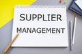 Supplier management memo written on a notebook with pencils, Conceptual business photo