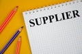 Suppliers - blue binder in the office. supplier word written on white notepad and yellow background