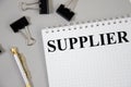 Suppliers - blue binder in the office. supplier written word on notepad and gray background