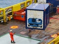 Supply boat transfer cargo to oil and gas industry and moving cargo from the boat to the platform. Workers remove cargo with crane