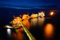 The supply boat is working at large offshore oil rig at night Royalty Free Stock Photo