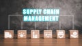 Wooden blok on desk with supply chain management icon on virtual screen