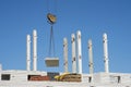 Supply of concrete slabs with a crane during the construction of a brick house. No body Royalty Free Stock Photo