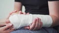 Support and care for the patient with a broken arm. The hand is in gypsum. Rehabilitation after injury, physiotherapy