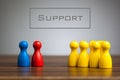 Support concept with pawn figurines on table Royalty Free Stock Photo