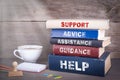 Support concept. Stack of books on wooden desk Royalty Free Stock Photo