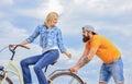 Support and friendship. Woman rides bicycle sky background. Service and assistance. Man helps keep balance ride bike