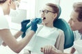 Nice girl with braces sitting in front of the dentist