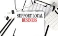 SUPPORT LOCAL BUSINESS word on notepad with clipboard , chart and calculator, business concept