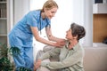 Professional physician touching shoulders of senior female at appointment