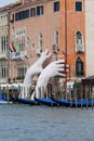 Support Sculpture by Lorenzo Quinn putting two giant hands protruding from the Grand Canal water, Venice, Italy