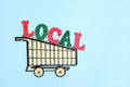 Support and shop local products concept. Wooden shopping cart with word local produce Royalty Free Stock Photo