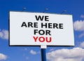 Support symbol. Words `we are here for you` on white billboard. Beautiful blue sky. Business and support concept. Copy space Royalty Free Stock Photo