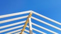 Supporting wooden structure for roof rafters, repeating beams on background of blue sky Royalty Free Stock Photo