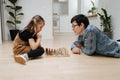 Supportive dad teaching chess to his child daughter, they play on the floor Royalty Free Stock Photo