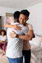 Supportive diverse male friends hugging each other and smiling at group therapy session Royalty Free Stock Photo