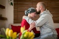 Supportive husband kissing his wife, cancer patient, after treatment in hospital. Cancer and family support.