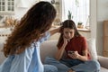 Mother comforting sad daughter rejected by friend. Upset teen girl looking at phone waiting for call