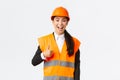 Supportive and pleased happy asian female chief engineer in safety helmet showing thumbs-up in approval, satisfied with