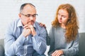 Supportive wife comforting her upset husband at meeting in counselor's office