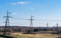 Supports high-voltage power lines against the blue sky with clouds. Electrical industry